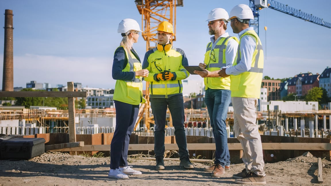 stock-photo-diverse-team-of-specialists-use-tablet-computer-on-construction-site-real-estate-building-project-181737