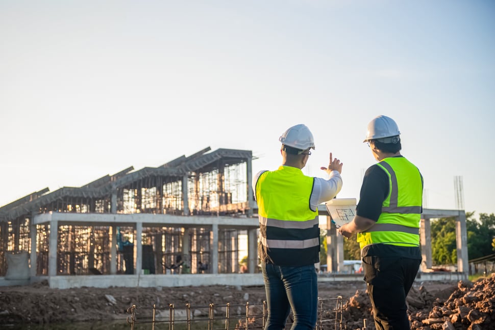 Zwei Architekten stehen vor einer Baustelle